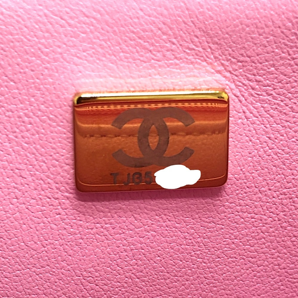 Gold cardholder with Chanel logo on a pink background