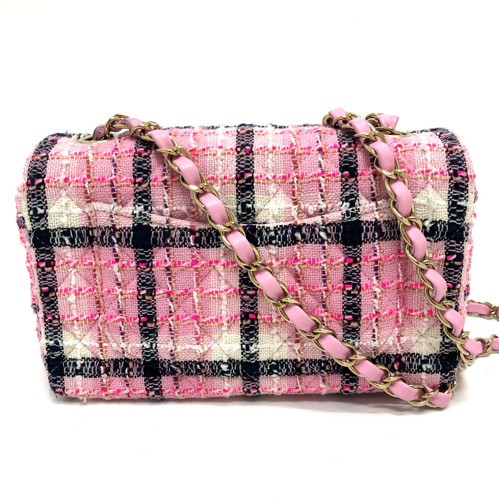Pink and black checkered handbag with a chain strap on a white background