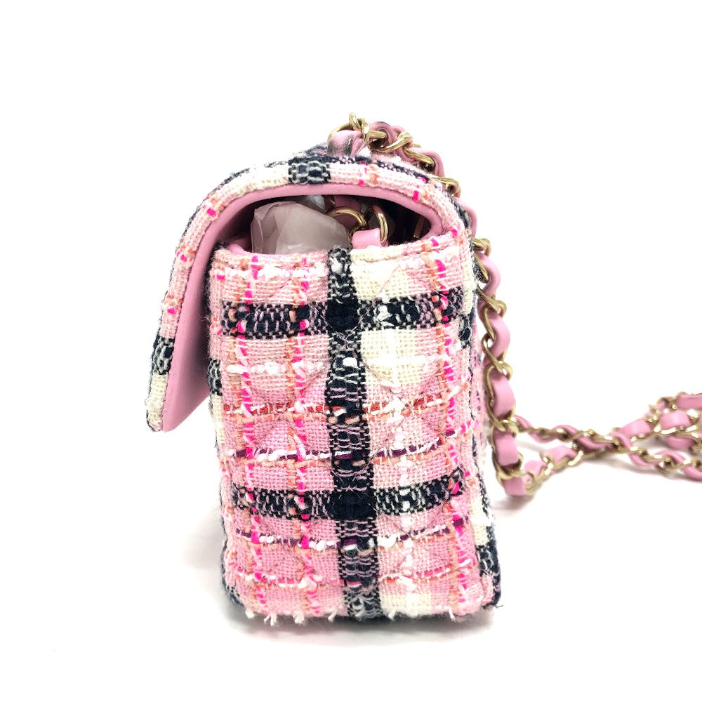 Pink and black checkered handbag with a chain strap on a white background