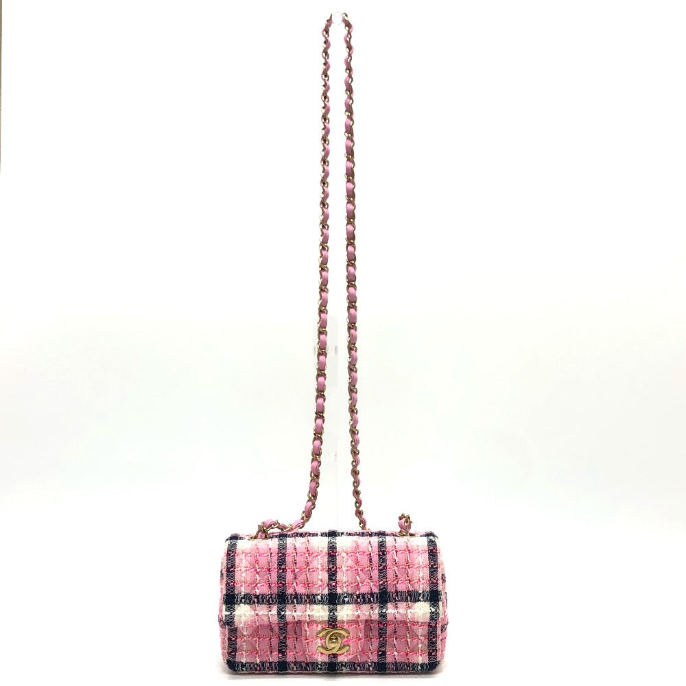 Pink and black checkered handbag with chain strap on a white background