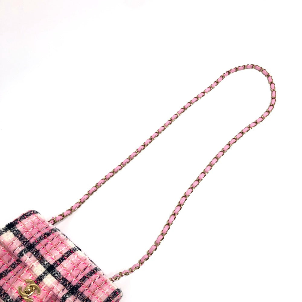 Pink and black checkered handbag with a chain strap on a white background