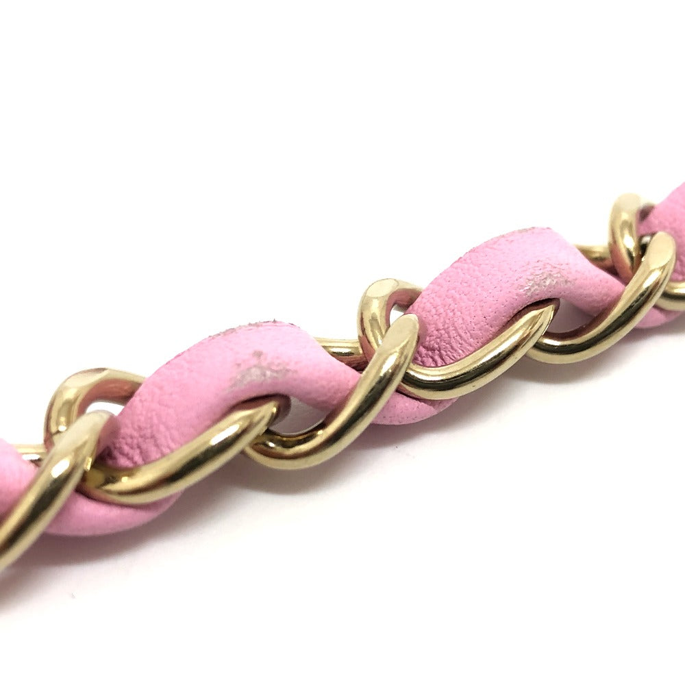 Close-up of pink leather chain with gold links on a white background