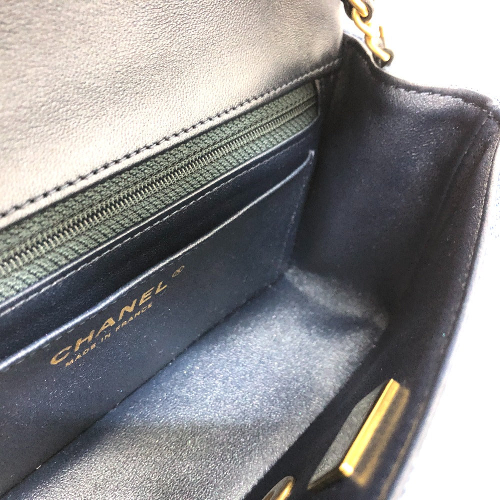 Close-up of a Chanel handbag with gold hardware on a white background