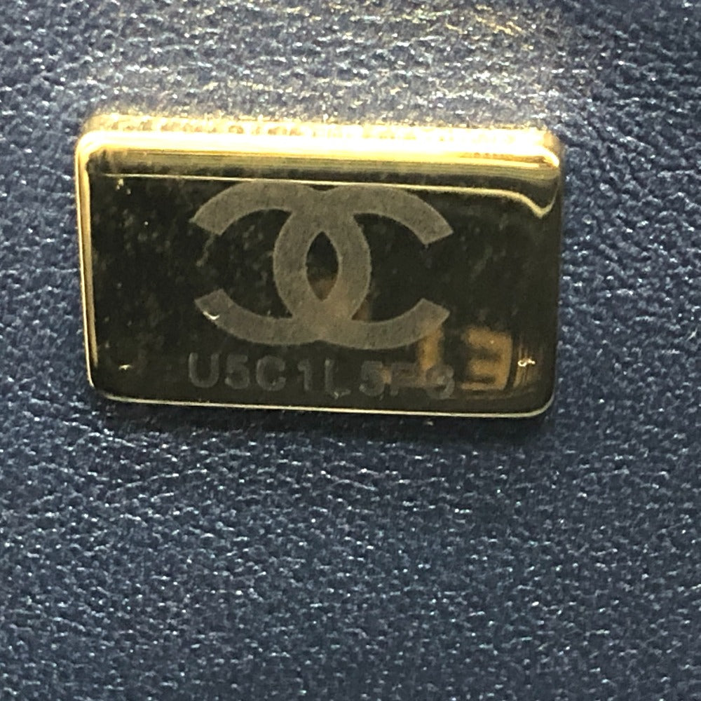 Gold and black rectangular object with a logo on a textured surface