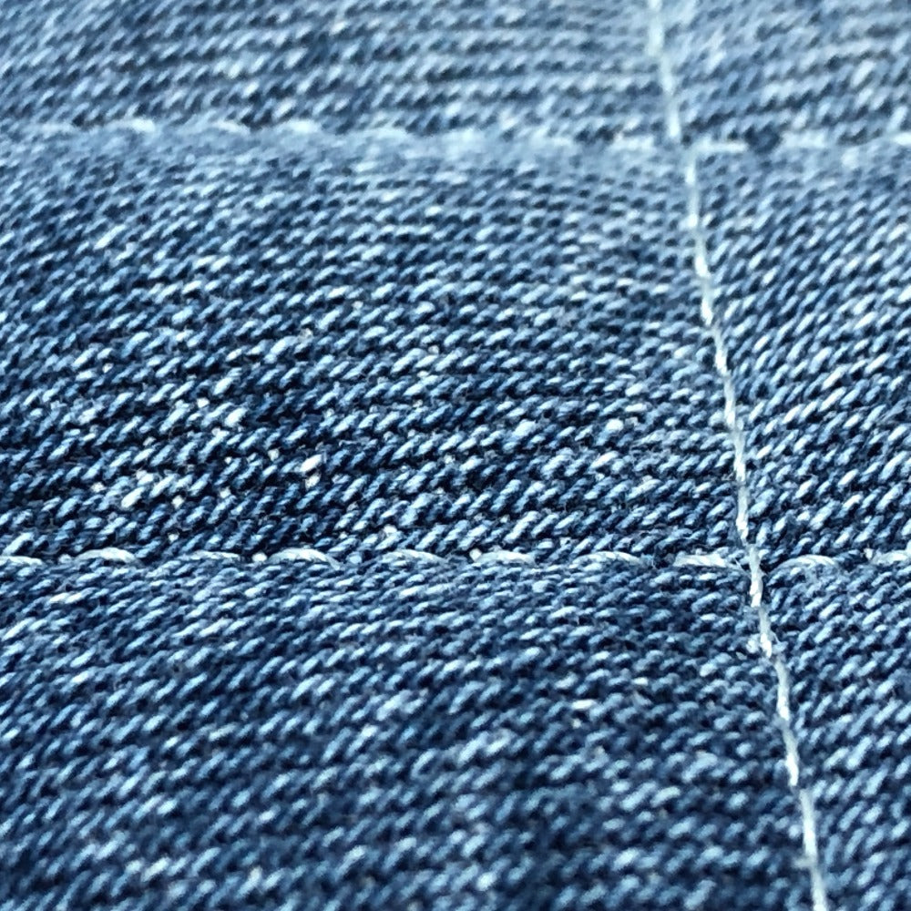 Close-up of blue denim fabric with a visible stitch
