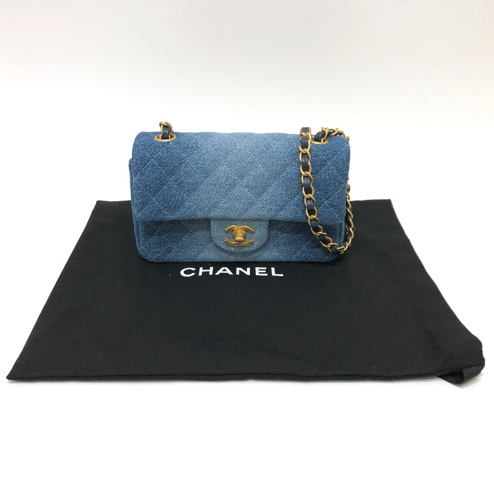 Blue quilted handbag with gold chain on a Chanel branded black pouch