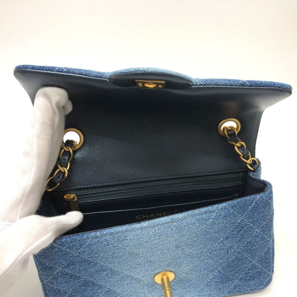 Blue Chanel handbag with gold hardware on a white background