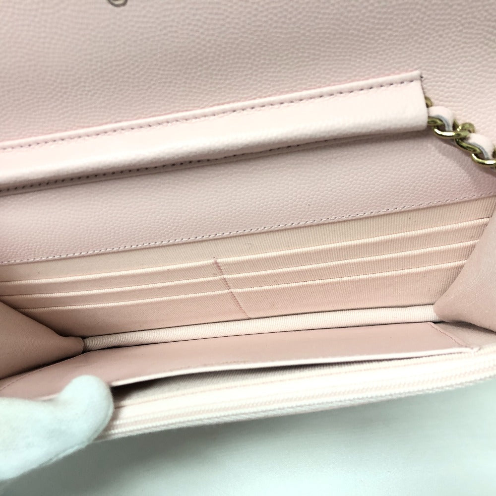 Close-up of a pink handbag with a gold chain strap on a light gray background