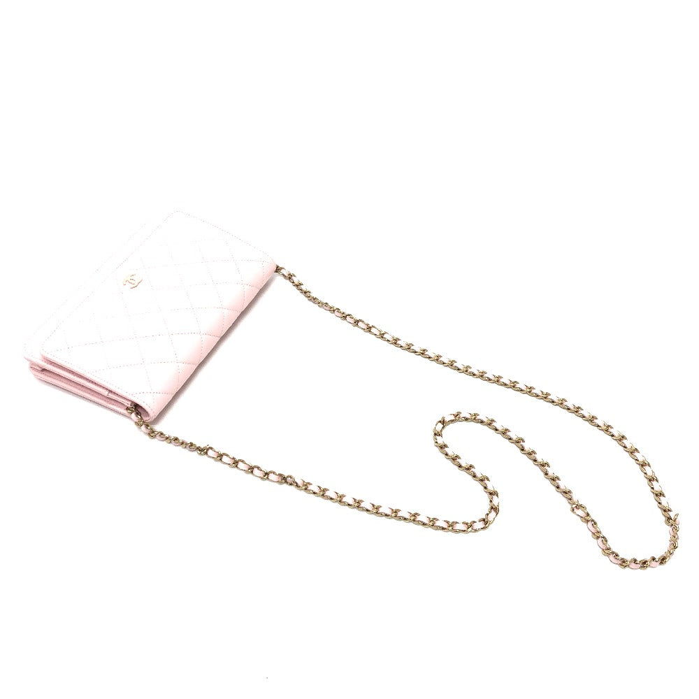 Pink comb with a gold chain on a white background