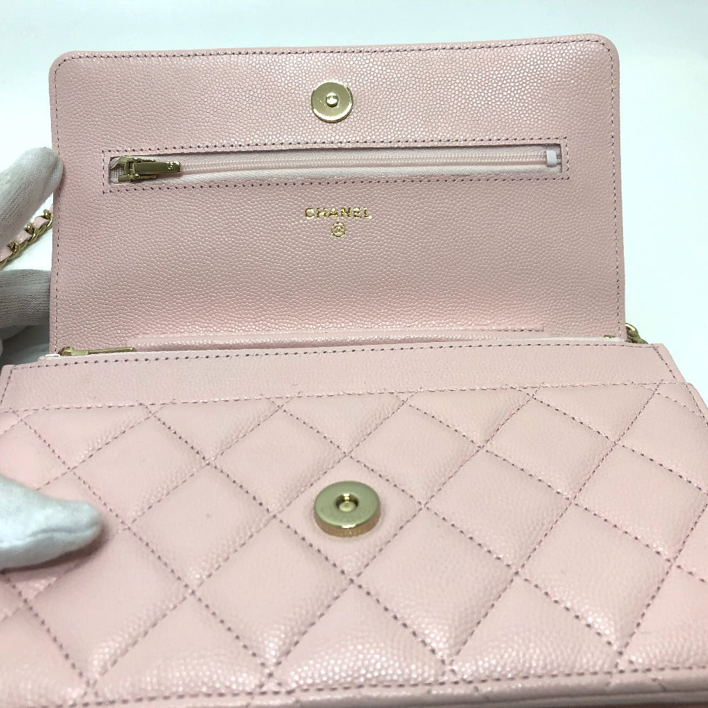 Pink quilted handbag with gold hardware on a light blue background