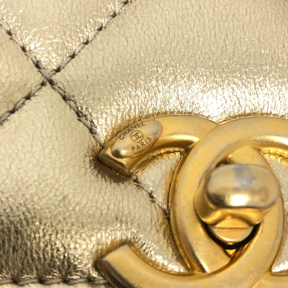 Close-up of a gold Chanel logo on a textured surface