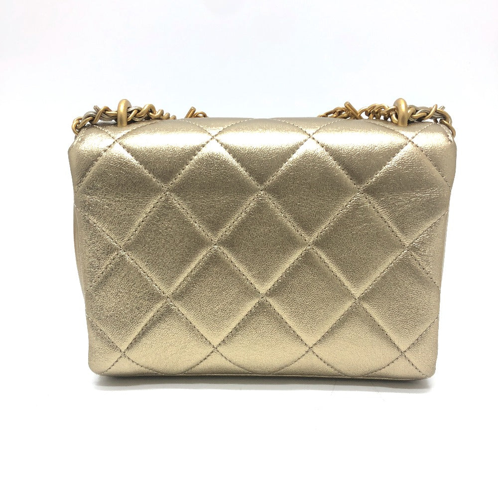 Gold quilted handbag with chain strap on a white background