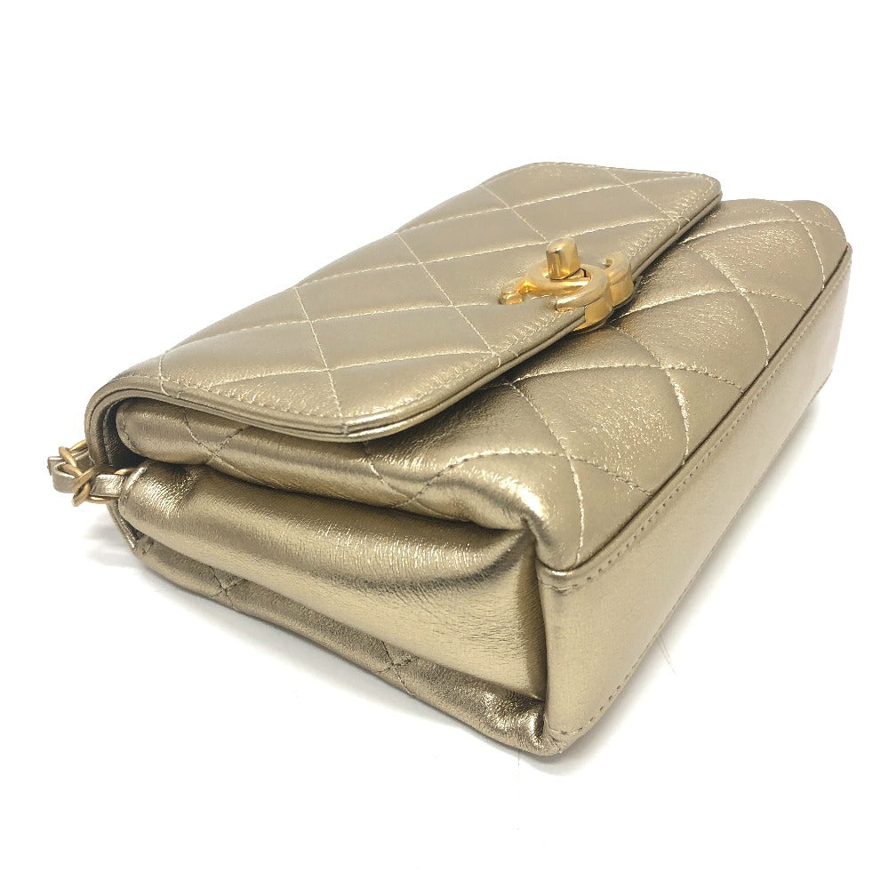 Gold quilted handbag with a gold clasp on a white background
