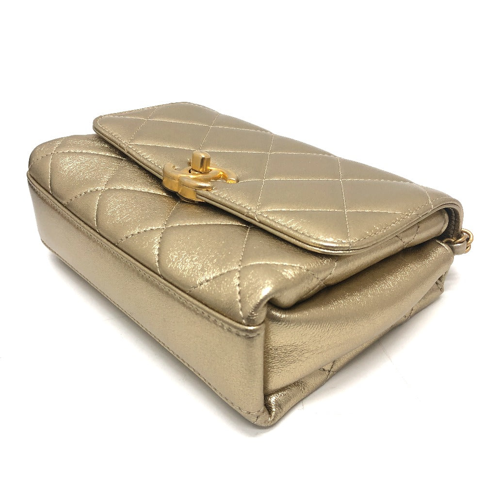 Gold quilted handbag with a gold clasp on a white background