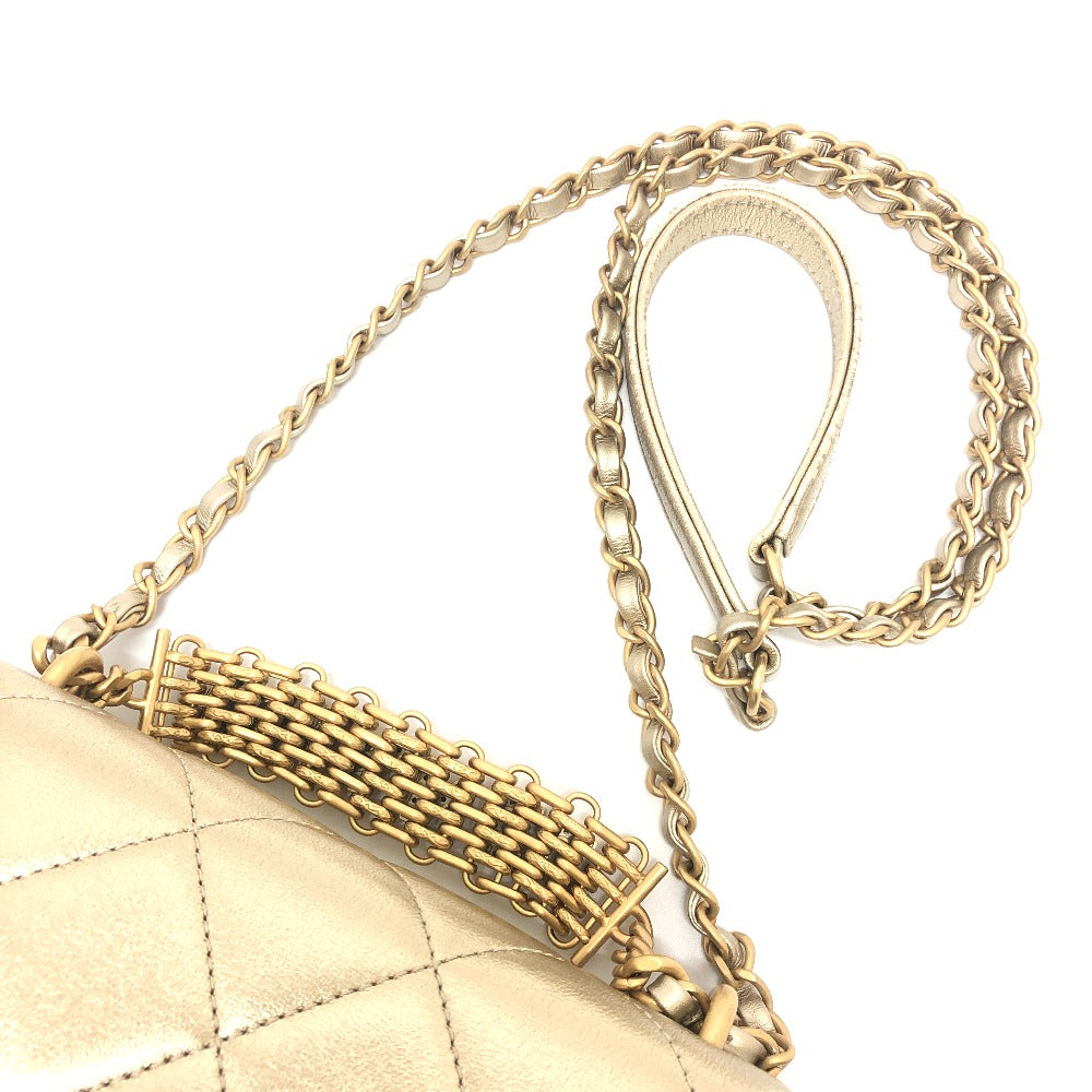 Gold chain strap on a quilted handbag with a white background