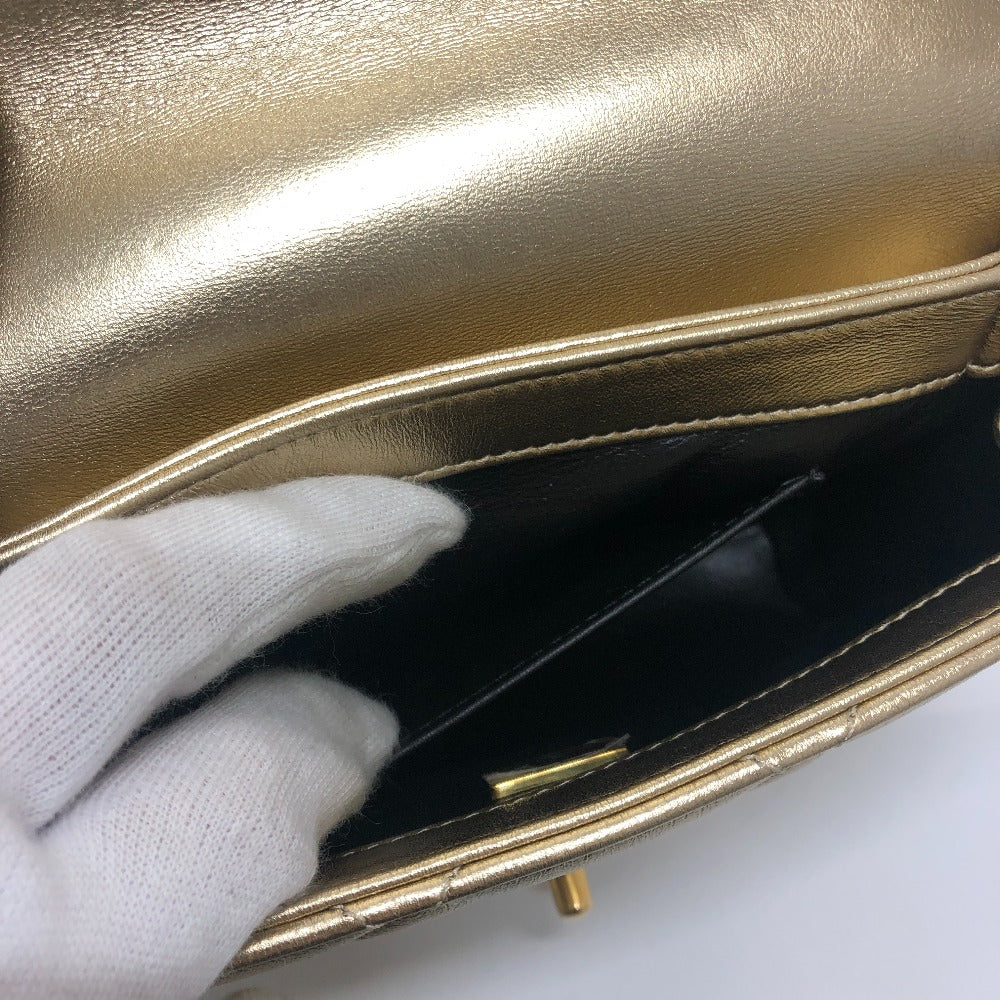 Gold handbag with a white glove opening it on a white background