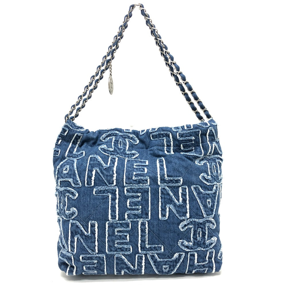 Blue denim handbag with white branding on a white background