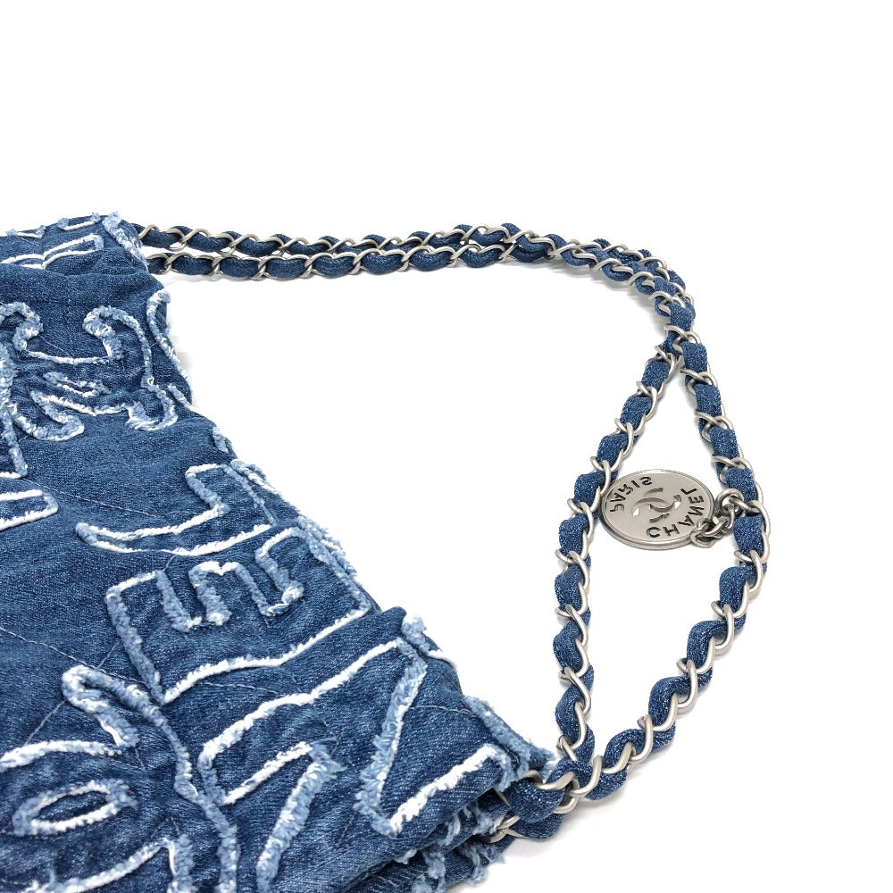 Blue drawstring bag with white patterns and a metal chain handle on a white background