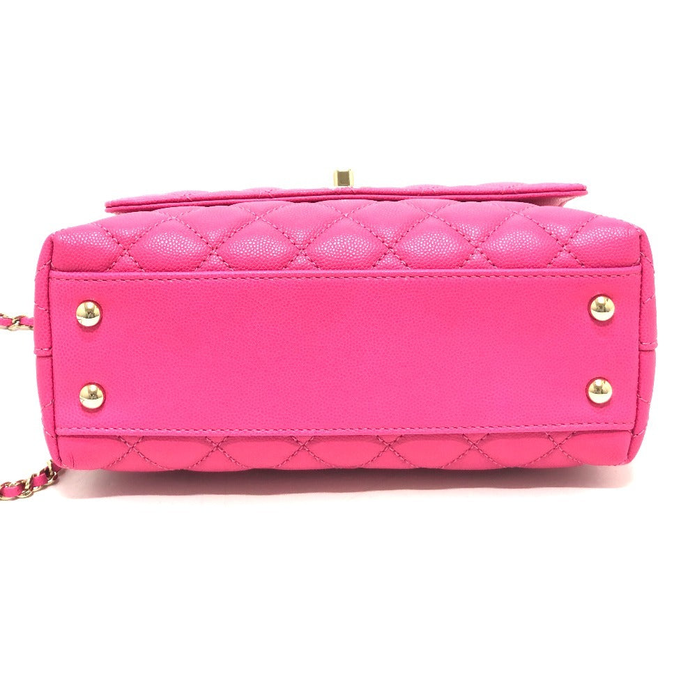 Pink quilted handbag with gold accents on a white background