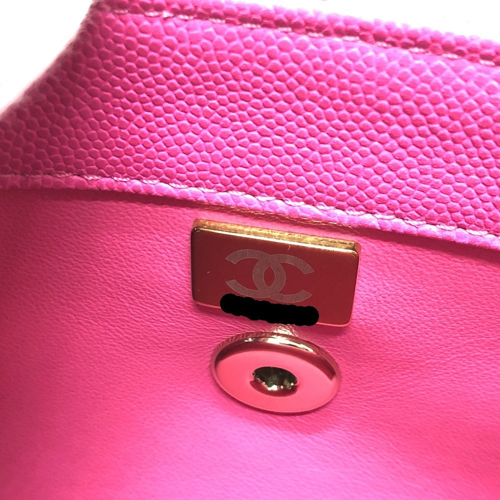 Close-up of a pink Chanel handbag with a gold logo tag.