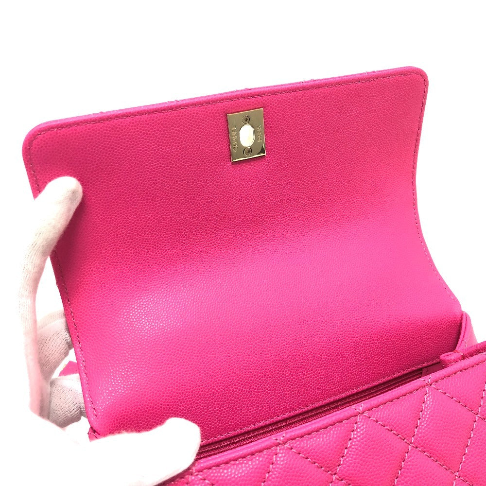 Pink clutch bag held by a hand on a white background