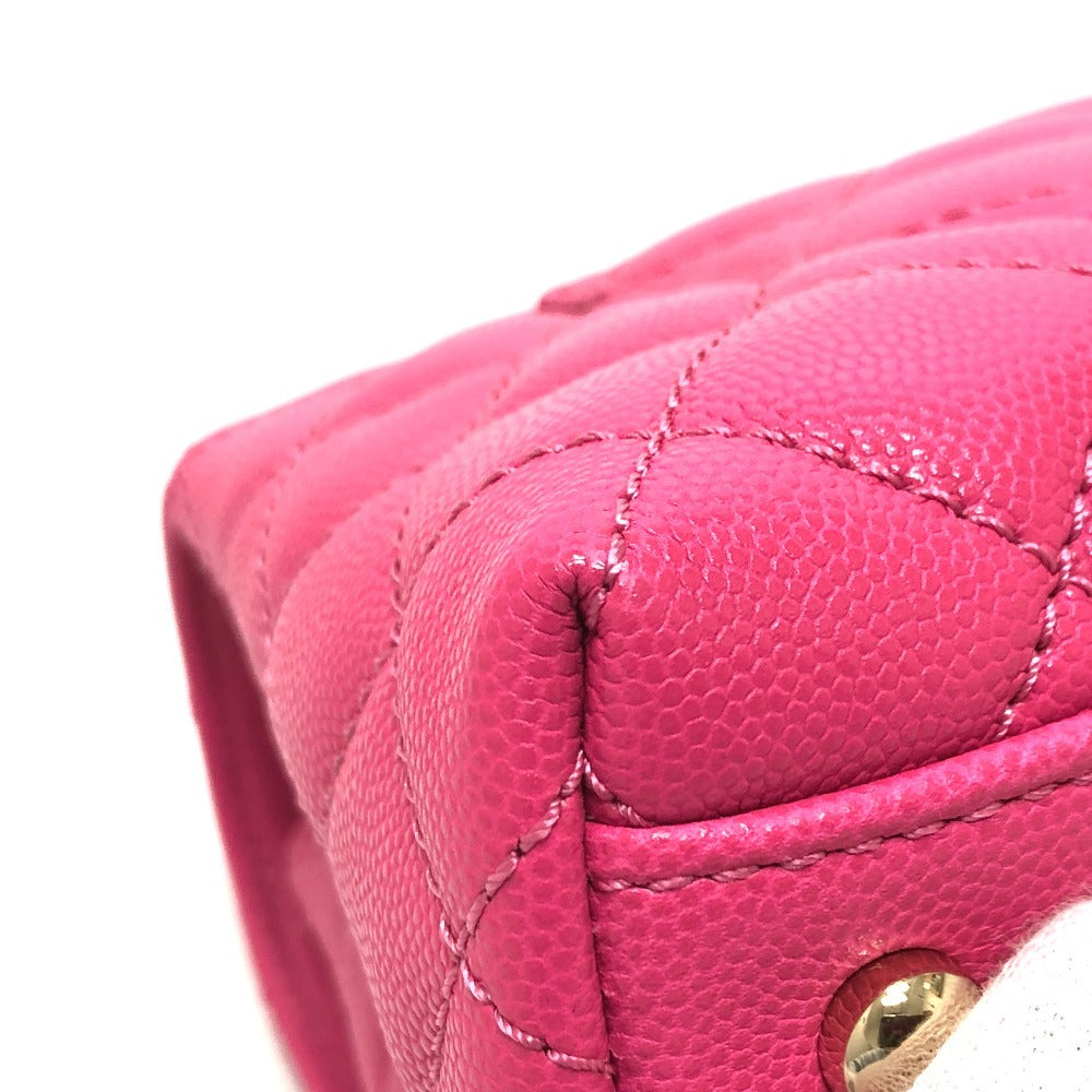 Close-up of a pink quilted handbag with a gold clasp on a white background