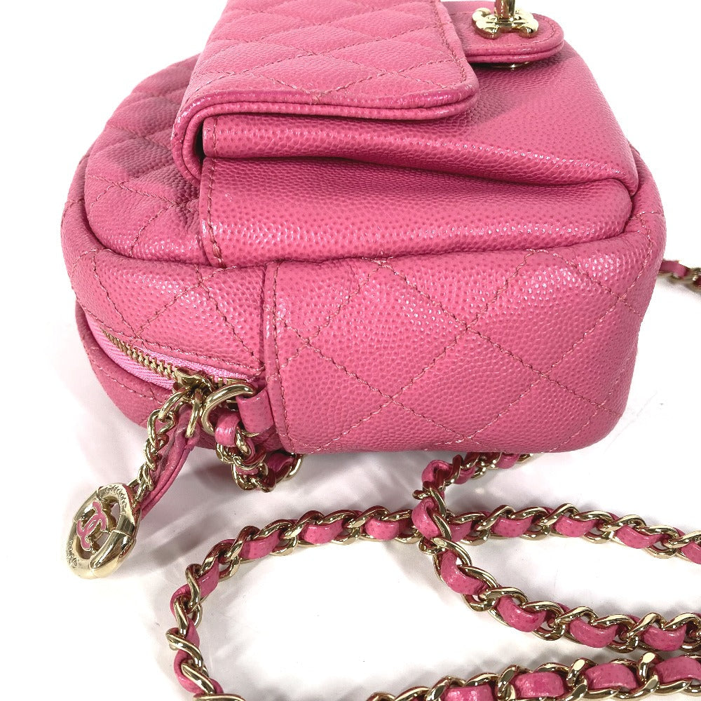 Pink quilted handbag with gold chain strap on a white background