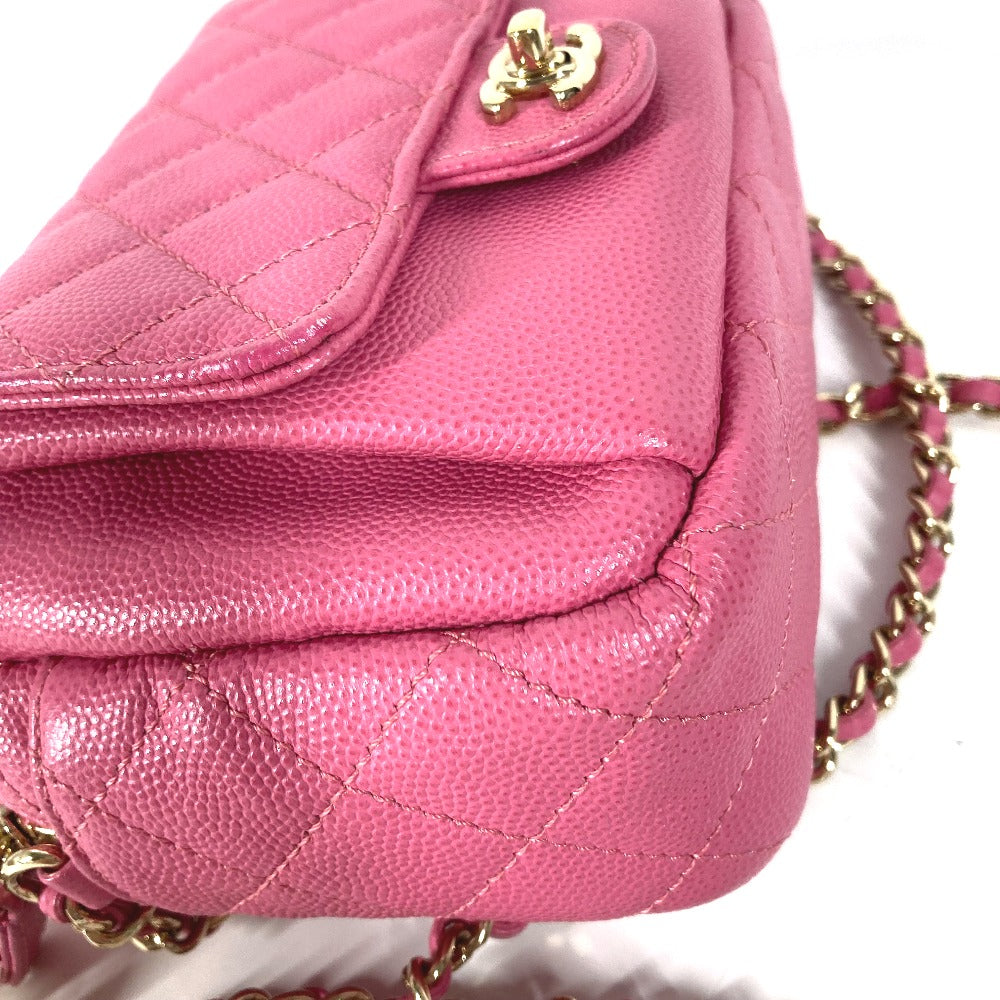 Pink quilted handbag with gold chain strap on a white background