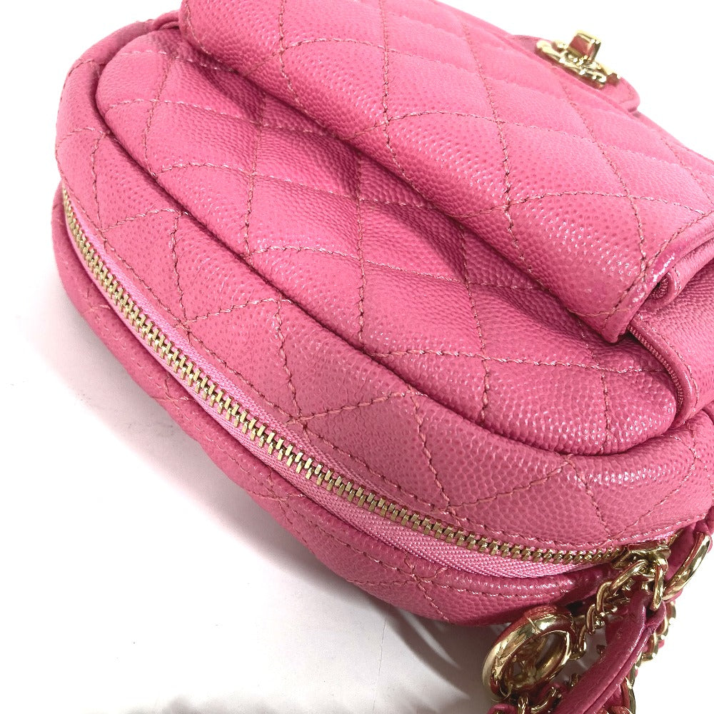 Pink quilted handbag with gold zipper and chain detail on a white background