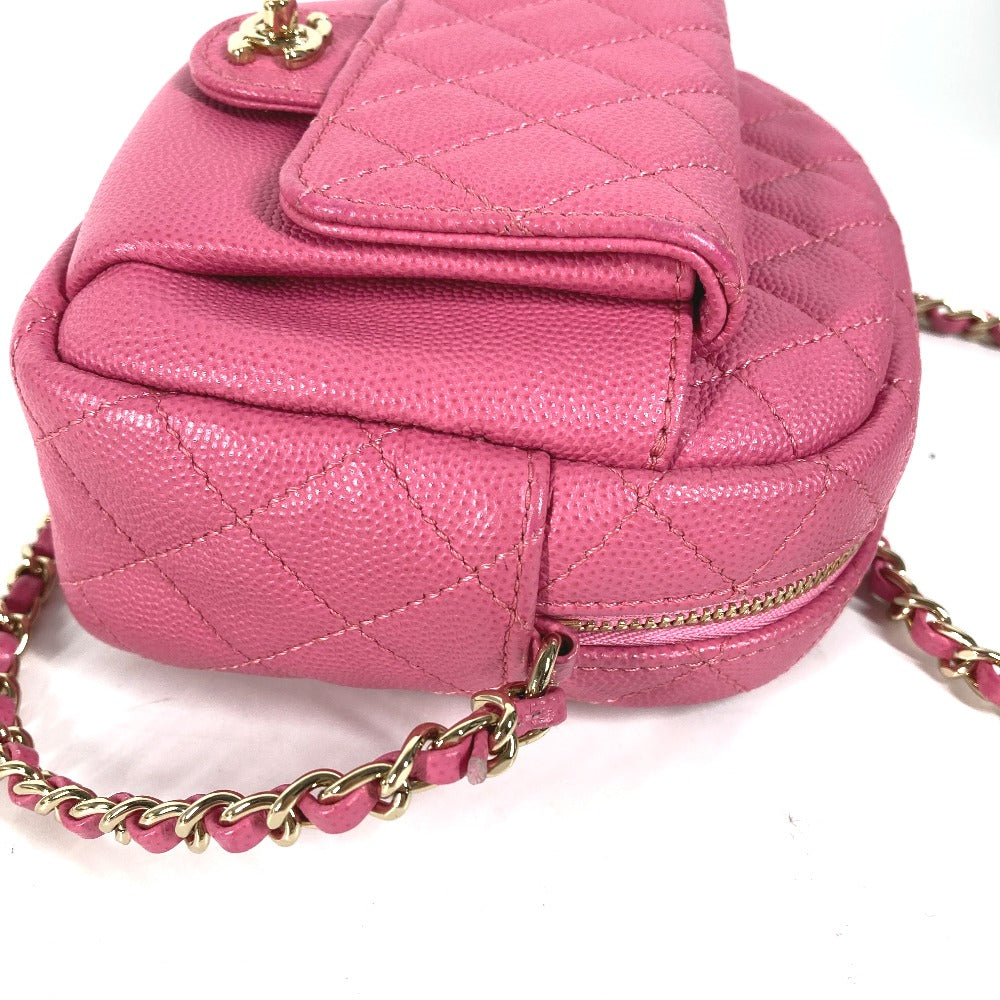 Pink quilted handbag with gold chain strap on a white background