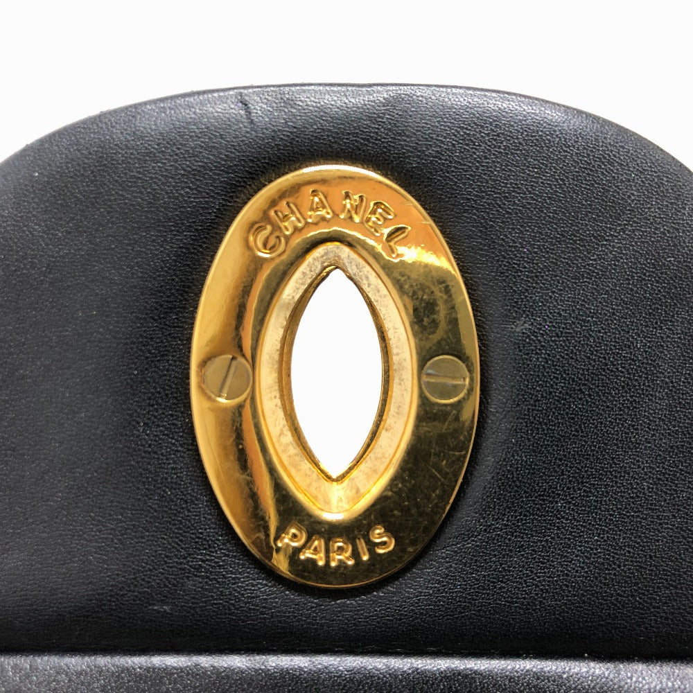 Black leather handbag with a gold Chanel Paris emblem on a white background