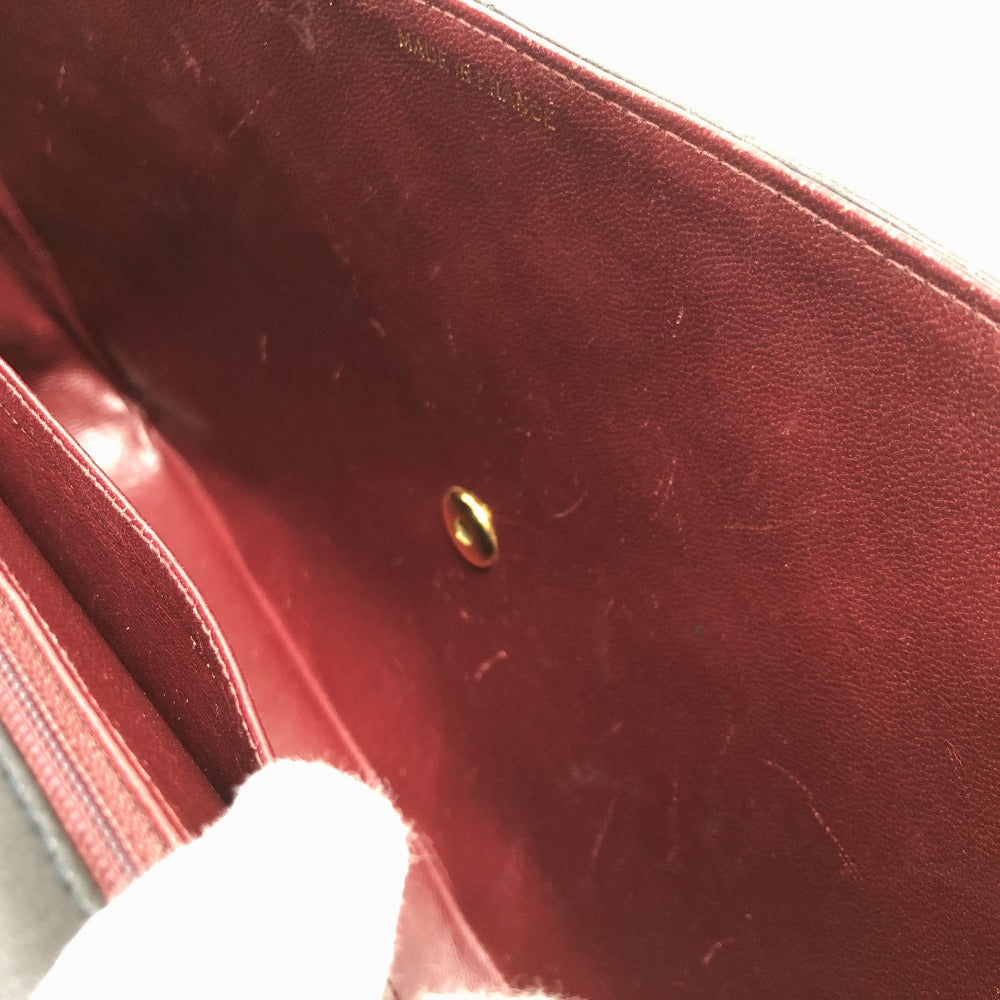Close-up of a red leather surface with a gold button