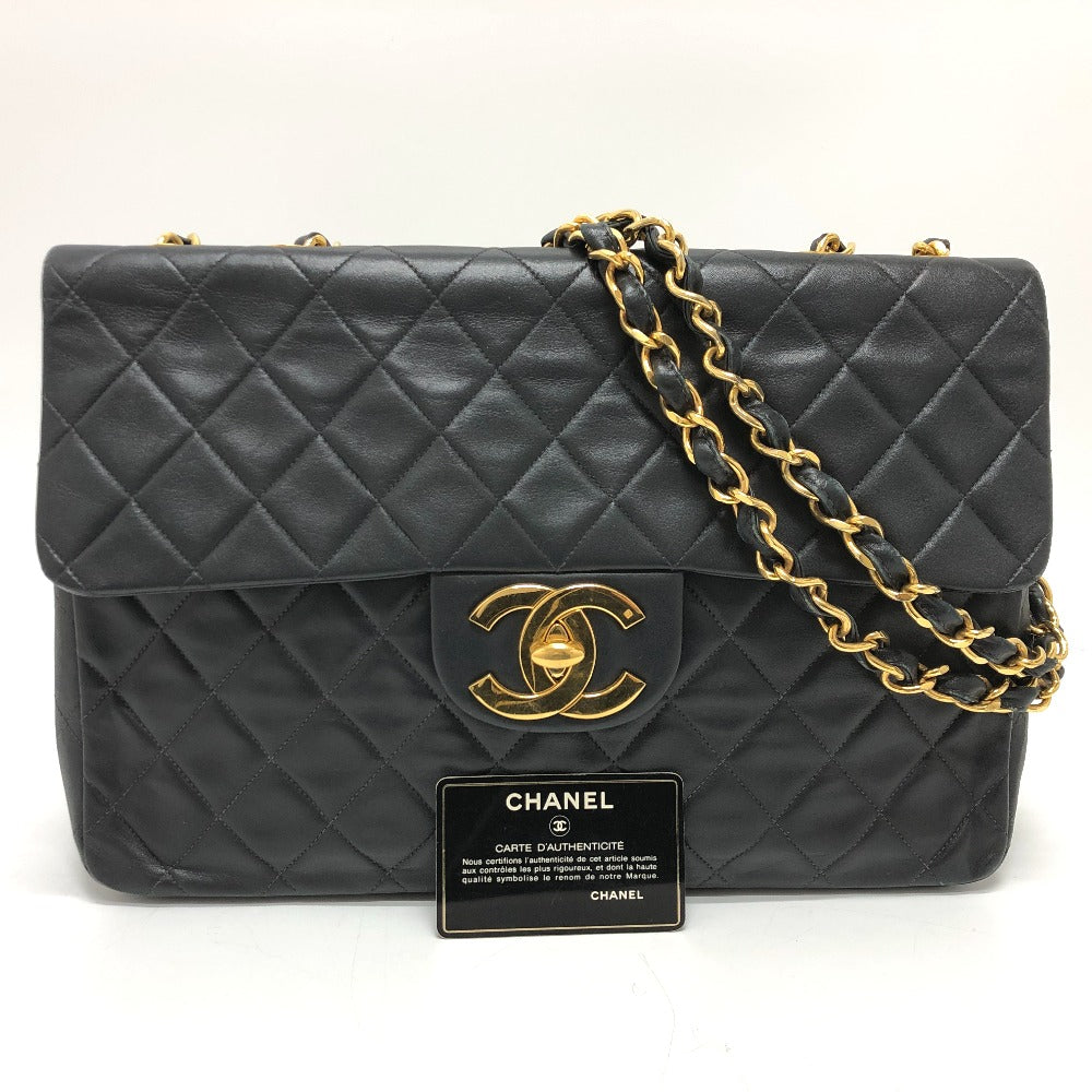 Black quilted Chanel handbag with gold chain strap on a white background