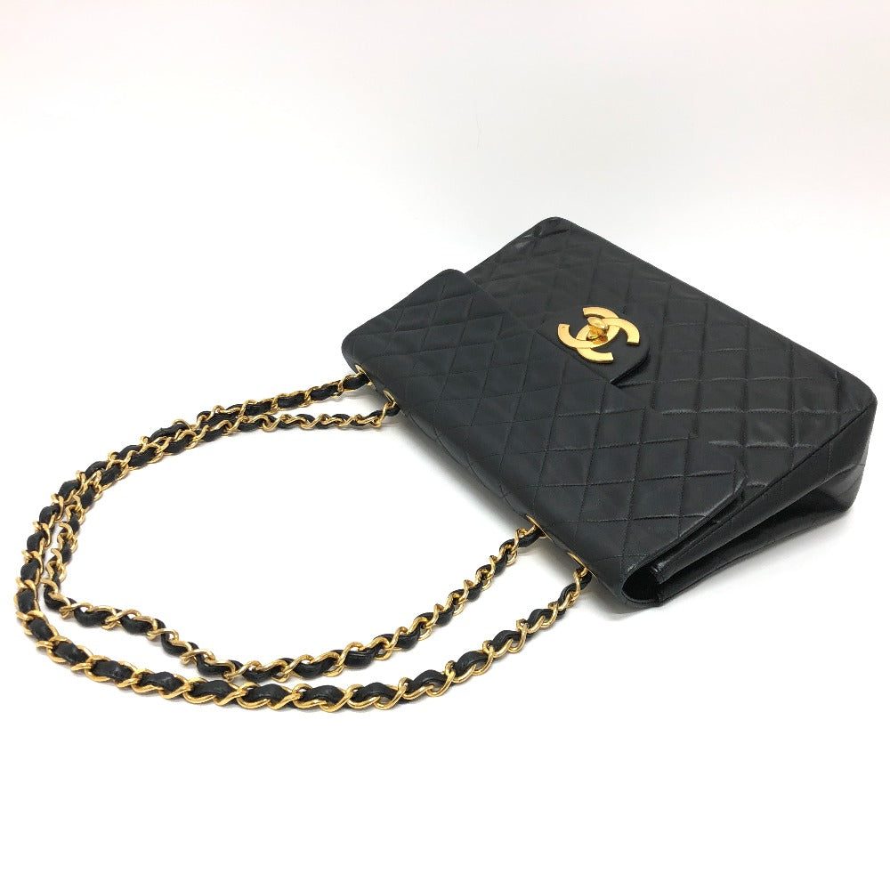 Black quilted handbag with gold chain on a white background