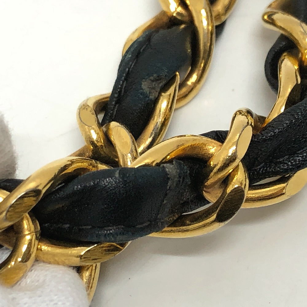 Gold chain with black leather interwoven on a white background