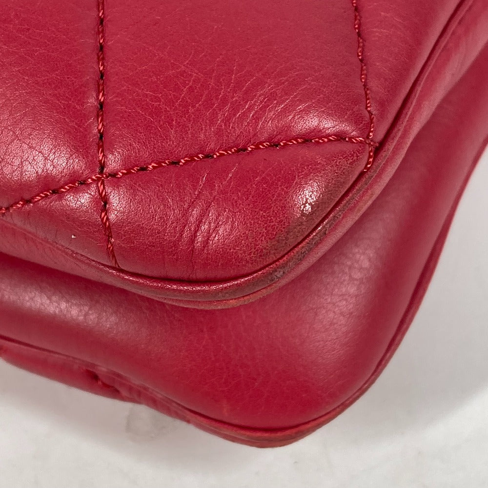 Close-up of a red leather product with visible stitching on a white background