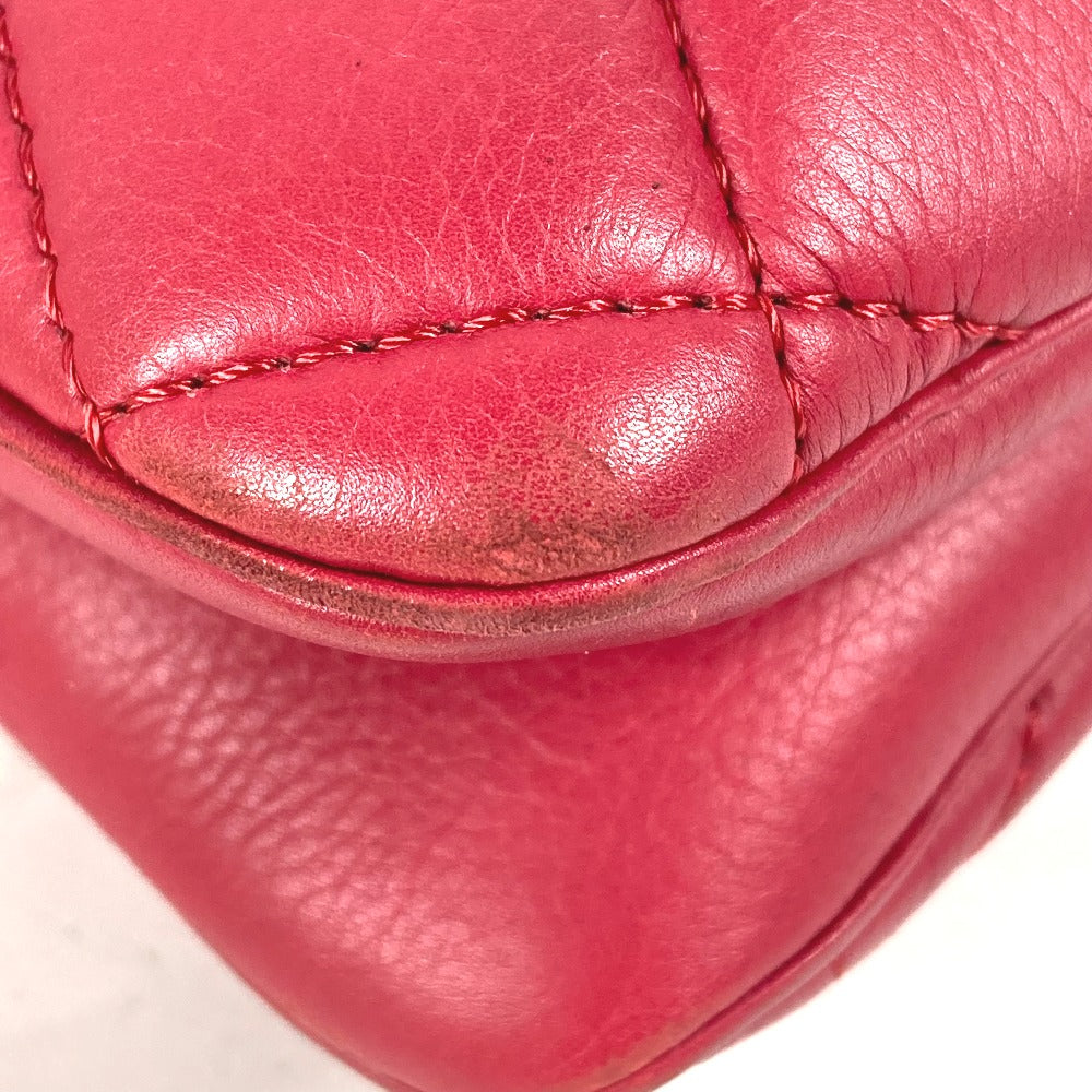 Close-up of a red leather product with visible stitching on a white background