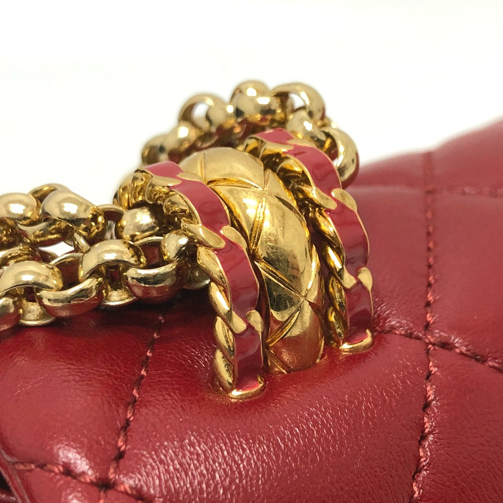 Close-up of a red quilted handbag with a gold chain detail on a white background