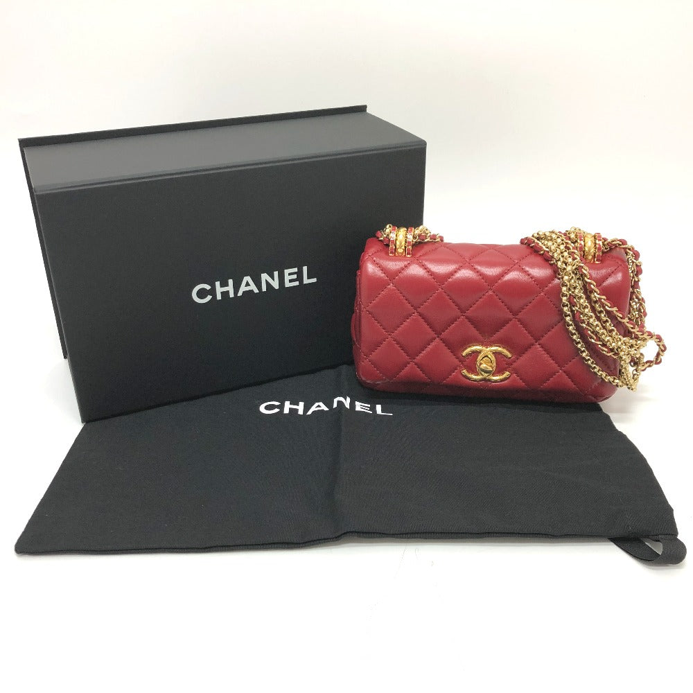 Red Chanel handbag with gold chain and black box on a white background