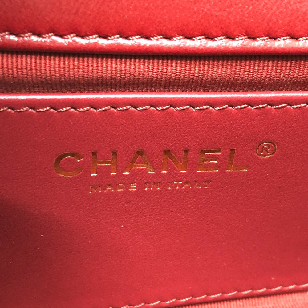 Close-up of a red Chanel handbag with gold logo and text.