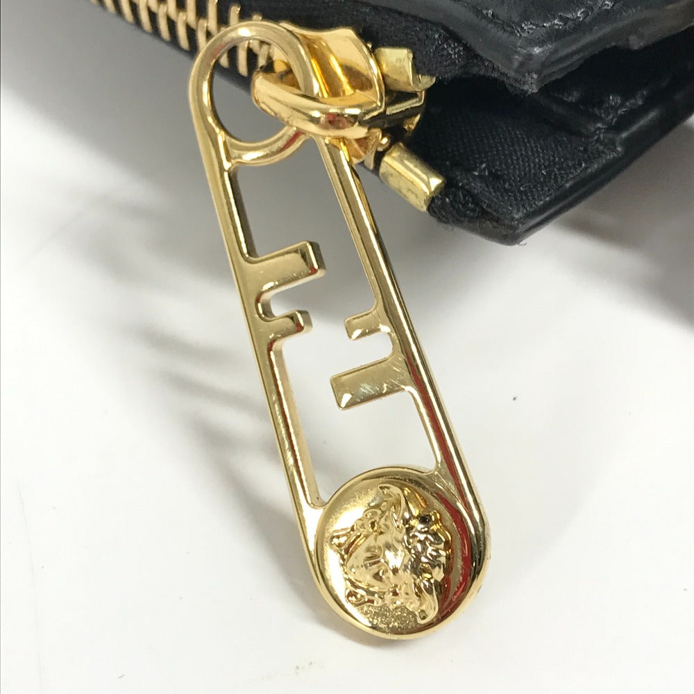 Gold zipper pull with brand logo on a black background
