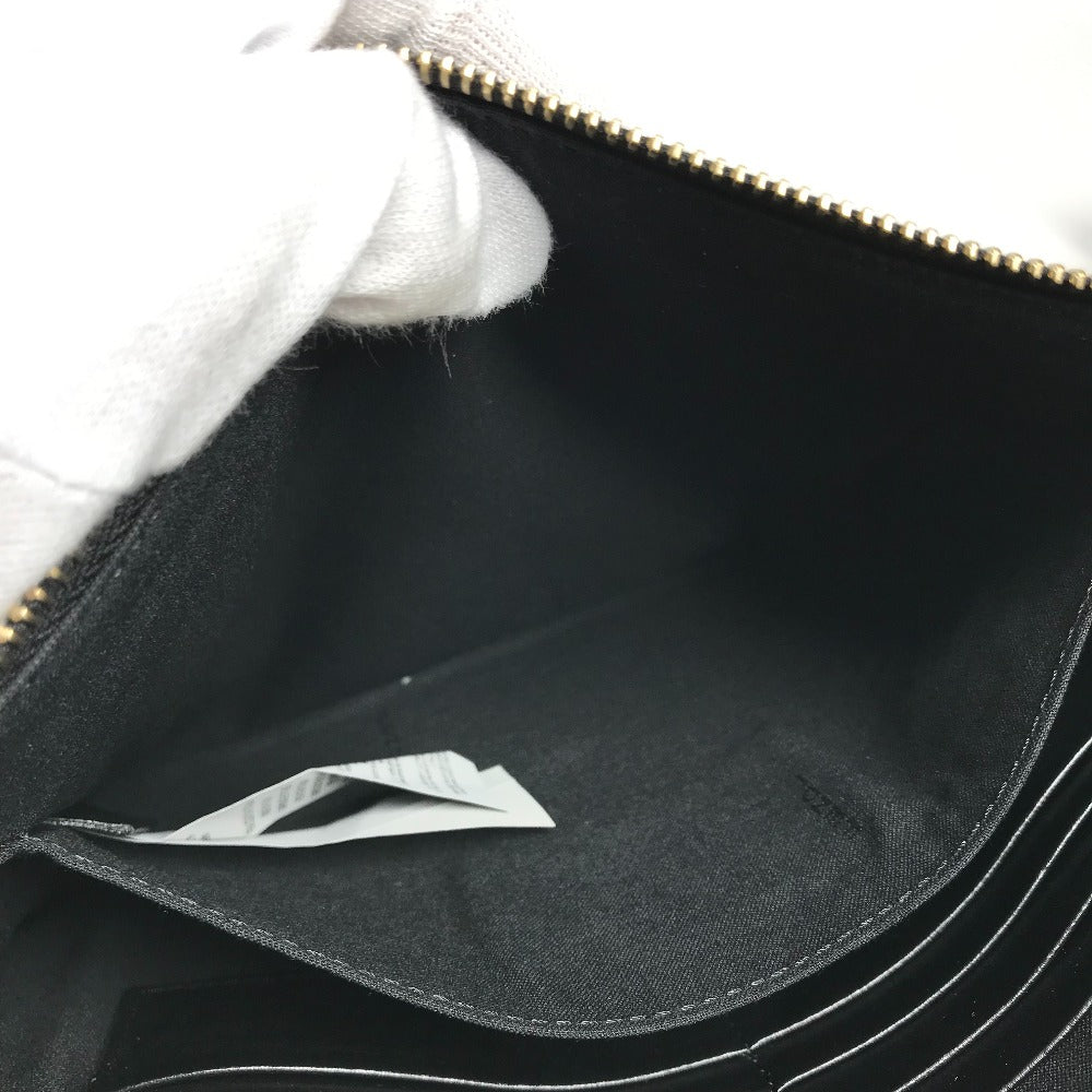 Close-up of a black bag with a gold zipper, showing the interior.