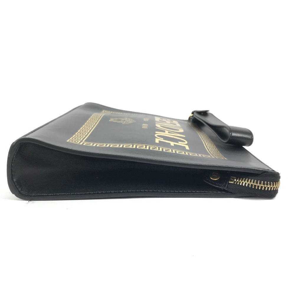 Black leather clutch with gold accents on a white background