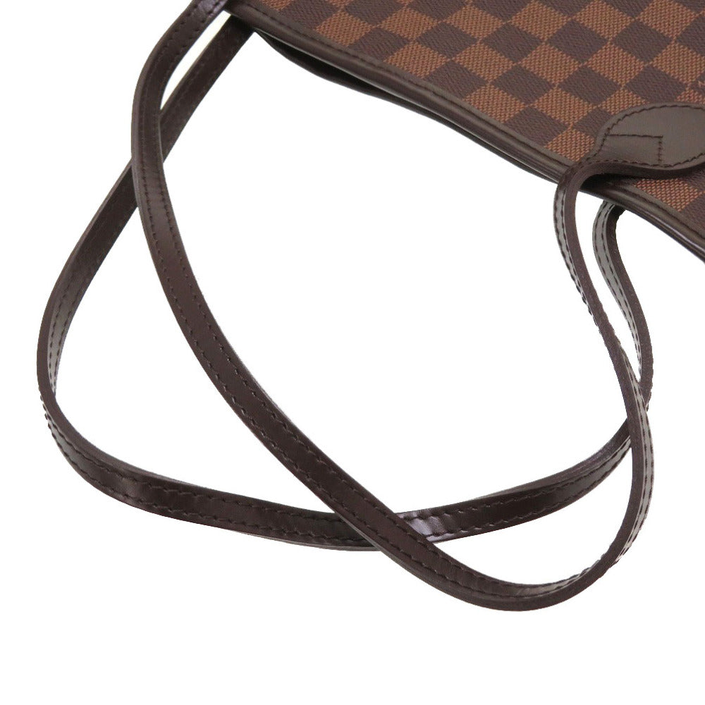 Close-up of a brown and black checkered handbag with a strap on a white background