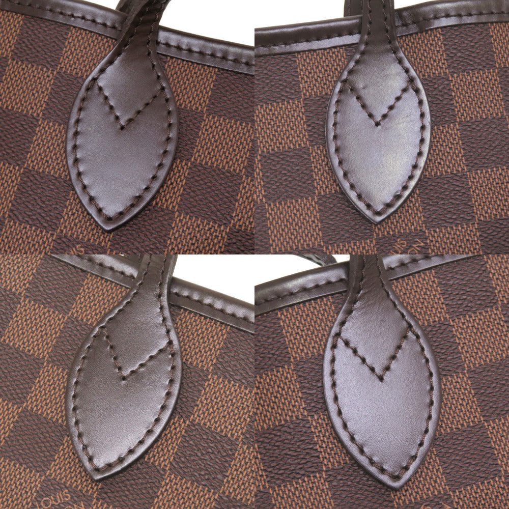 Close-up of a brown checkered handbag with leather handles.