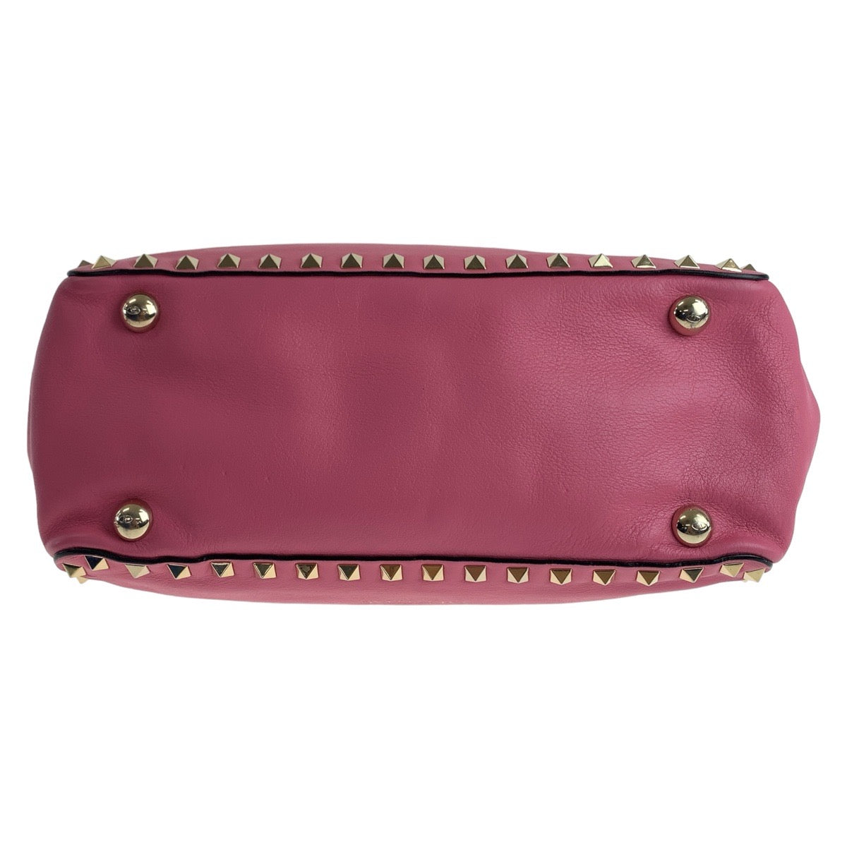 Pink handbag with gold studs on a white background