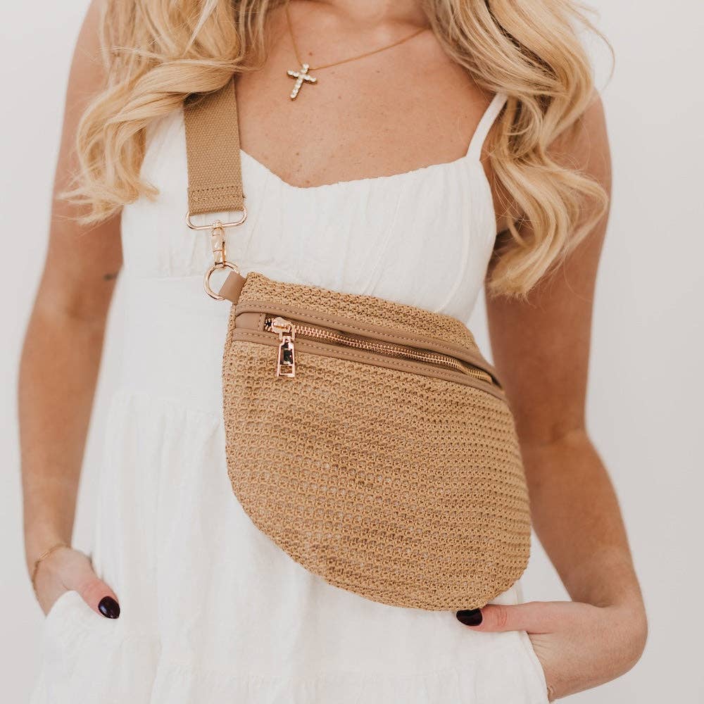 Woman wearing a beige woven fanny pack with a plain background