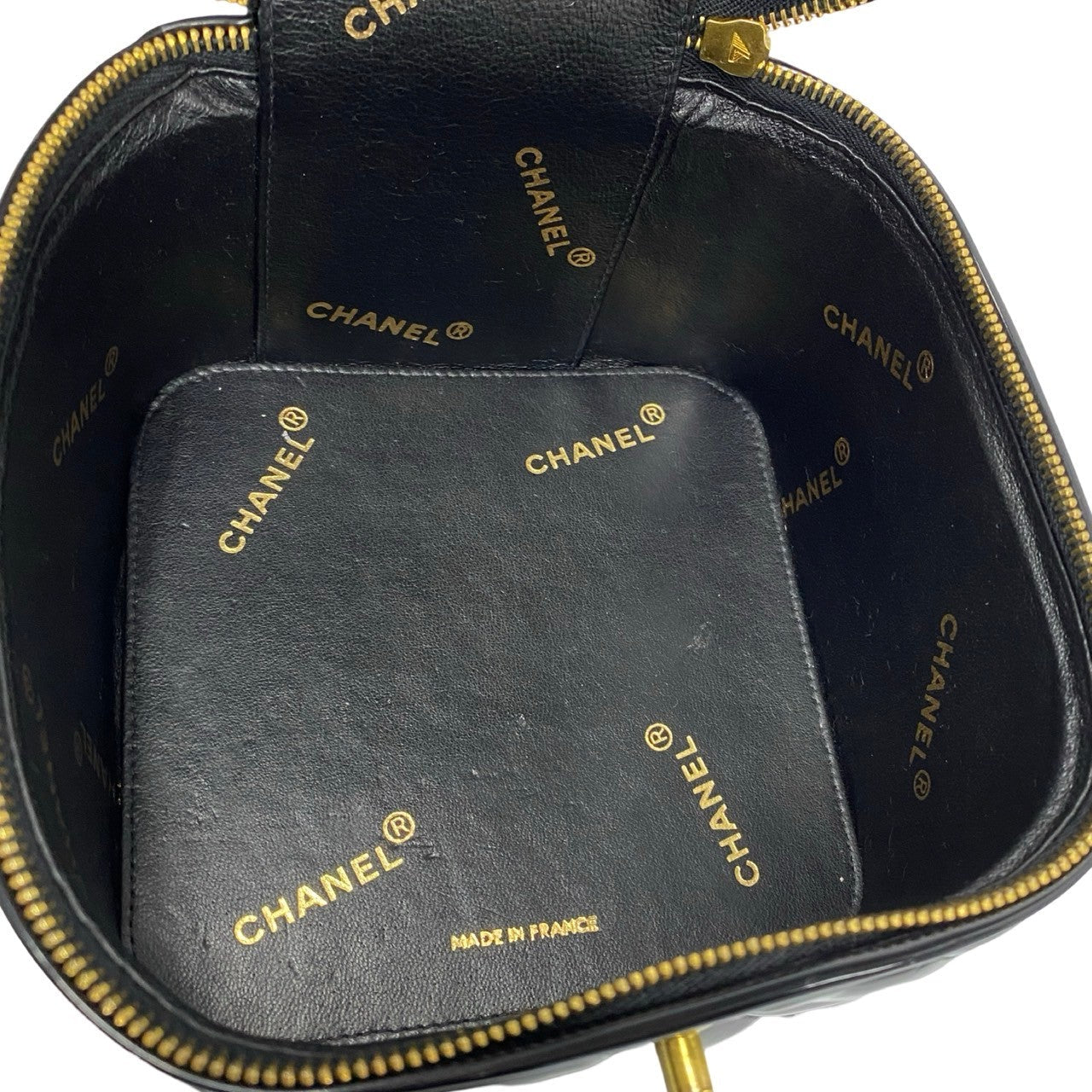 Chanel black pouch with gold lettering on a white background