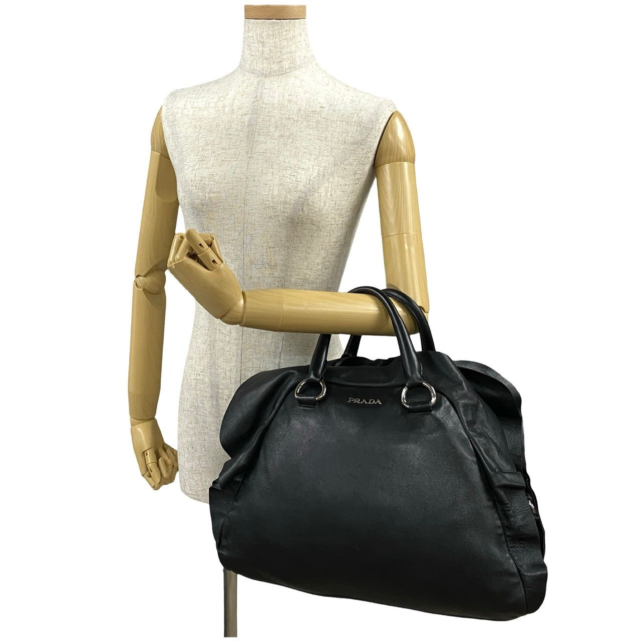 Black Prada handbag on a mannequin with a white background