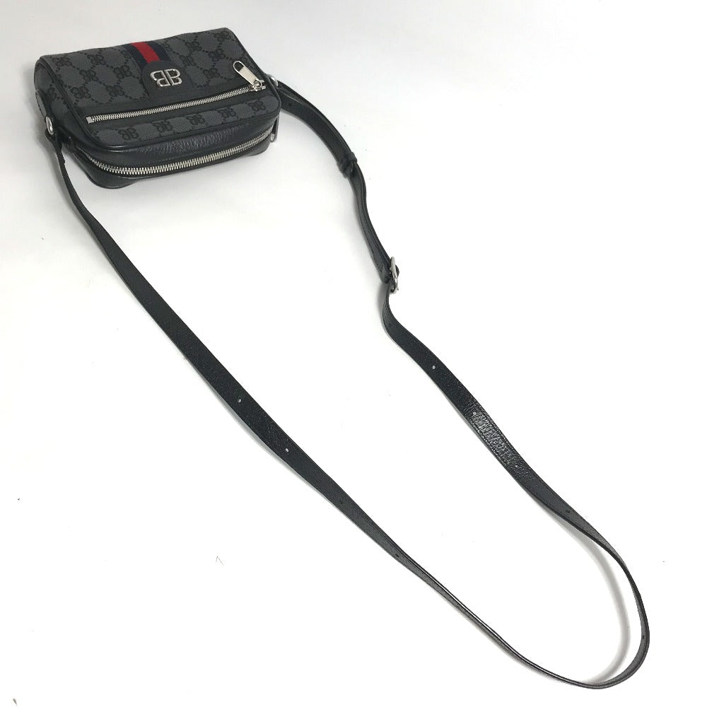 Black crossbody bag with a long strap on a white background